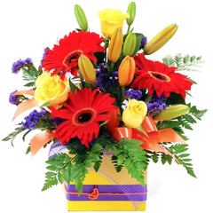Rainbow Bright Flower Arrangement: Yellow, orange, red, and purple box arrangement with roses and lilies.