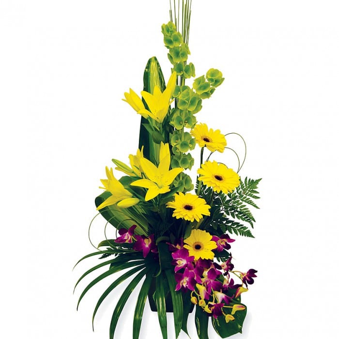 Seduction Orchids: Purple, green, and yellow box arrangement with lilies, gerberas, and orchids.