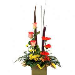 Orange Kisses Arrangement: Yellow and orange box arrangement with roses, chrysanthemums, and spear grass.