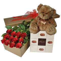 A Valentine’s gift box of 12 long-stem red roses, a medium box of chocolates, and a soft toy teddy bear.