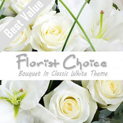 A classic white bouquet of fresh seasonal flowers, wrapped with greenery for a timeless look.