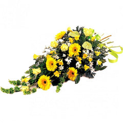A fresh sheaf of yellow, white, and green anthuriums, freesia, daisies, gerberas, and roses with molucca balm.