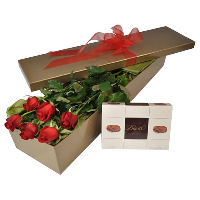 A romantic gift of six long-stem red roses paired with a box of chocolates, wrapped elegantly.