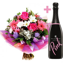 A vibrant pink and white bouquet of gerberas, roses, ageratum, and spray carnations with a 750ml bottle of Pink by YellowGlen.